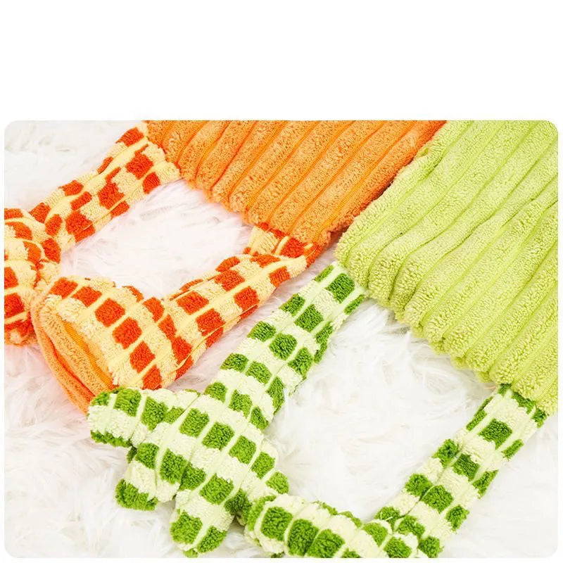 Green and orange plush dog toy with squeaker for aggressive chewing and teeth grinding