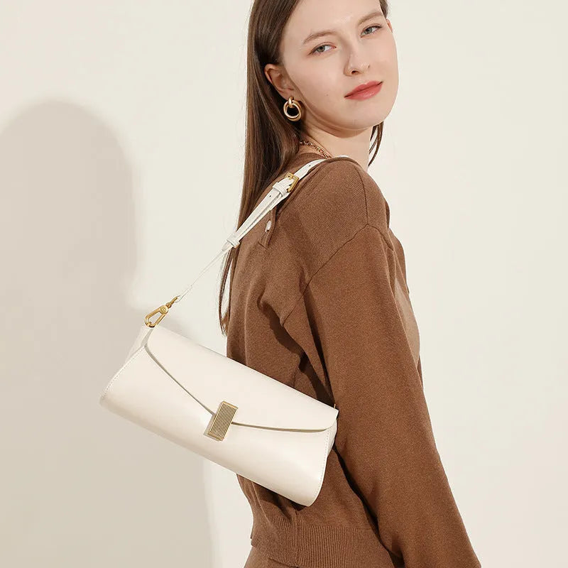 Women's leather cross-body bag with clamshell opening in milky white colour showing pillow-shaped design