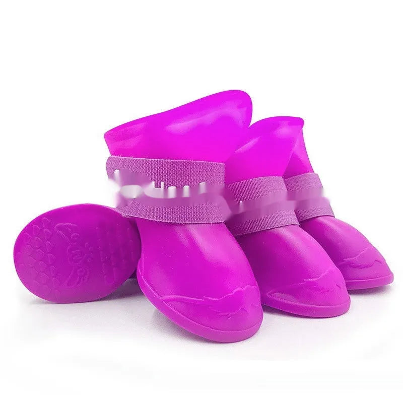 Four rubber pet rain shoes in various colours with anti-slip soles for dog paw protection