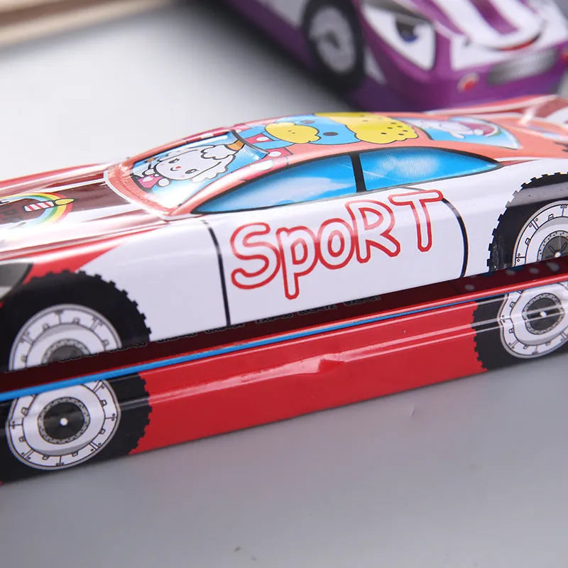 Metal tinplate stationery box with racing car trolley cartoon pattern, shown closed.