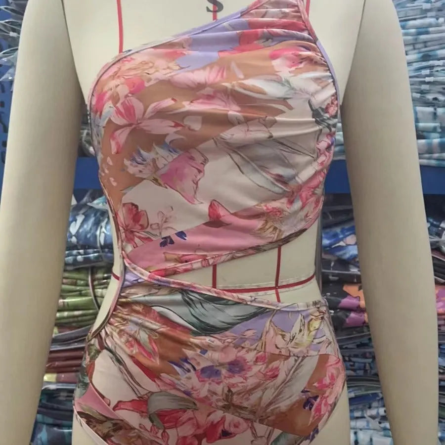 Rose gold patterned women's one-piece swimsuit on a hanger.