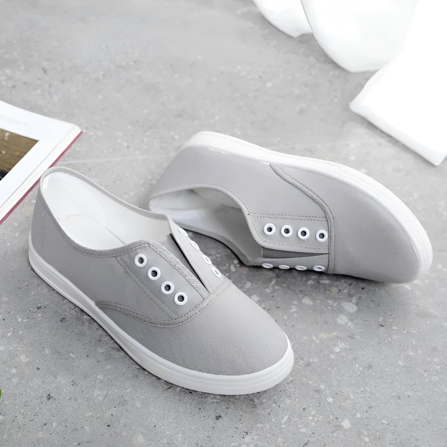 A pair of low-top canvas casual shoes in black with a flat plastic sole