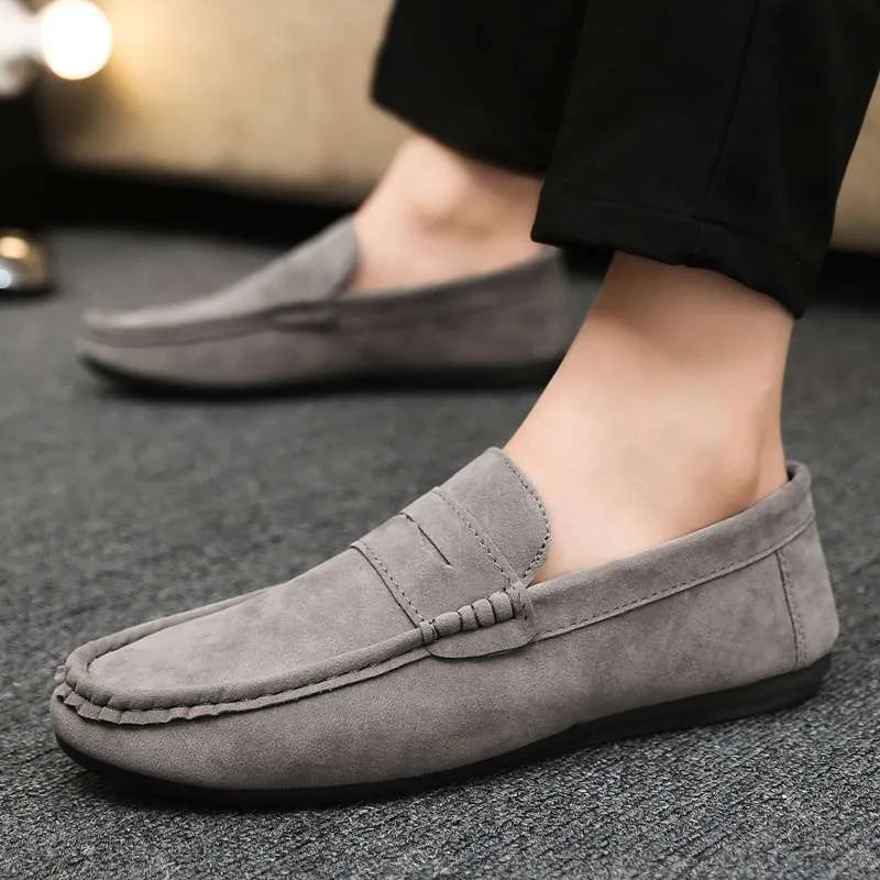 Men's black Gommino style slip-on loafers with round toe and textured rubber sole.