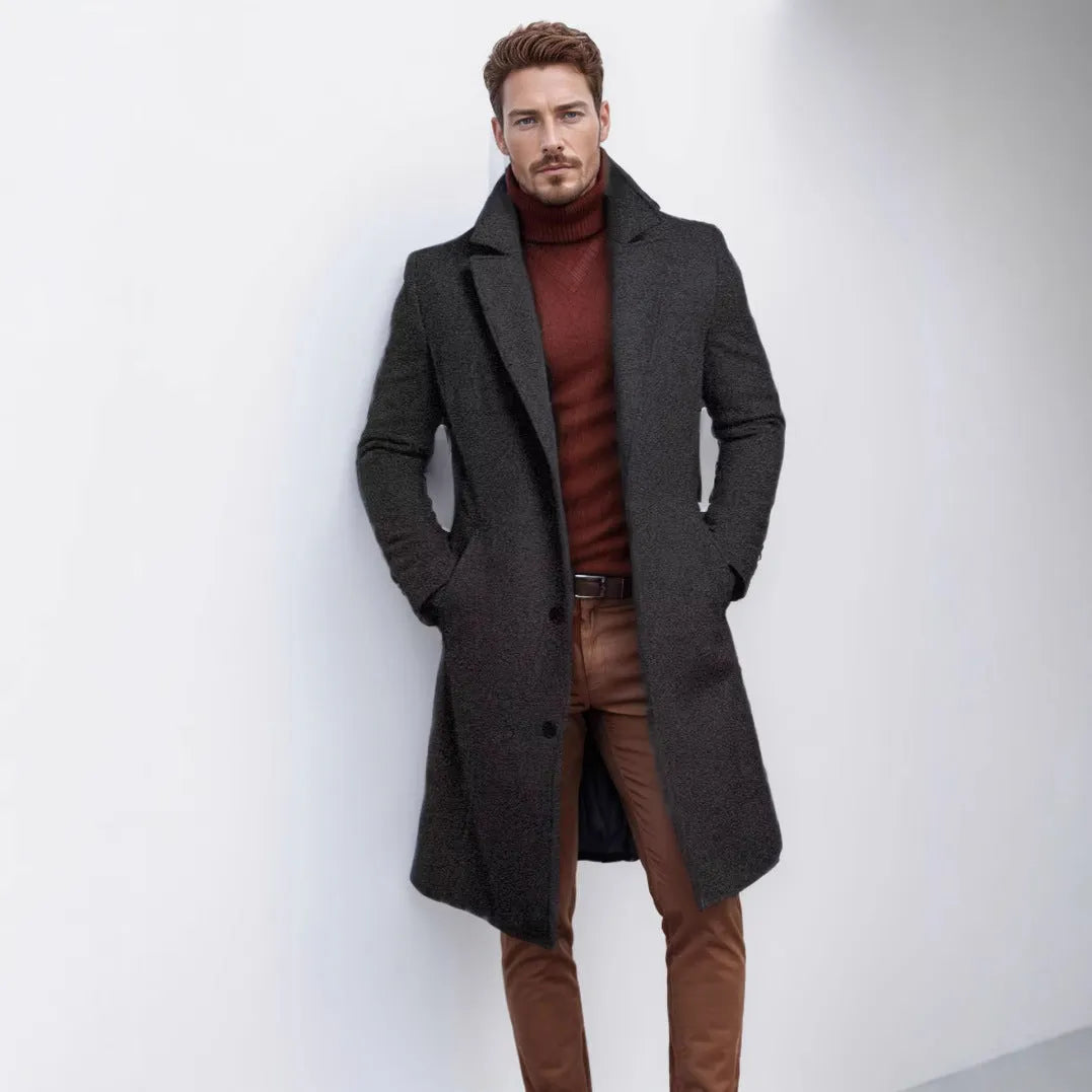 Men's mid-length solid colour woolen coat in dark gray, side view, showing thick fabric and side seam pocket.