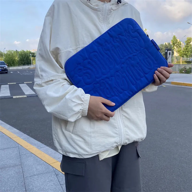 Embroidered blue silk laptop liner bag with letter pattern and cotton lining on a white background
