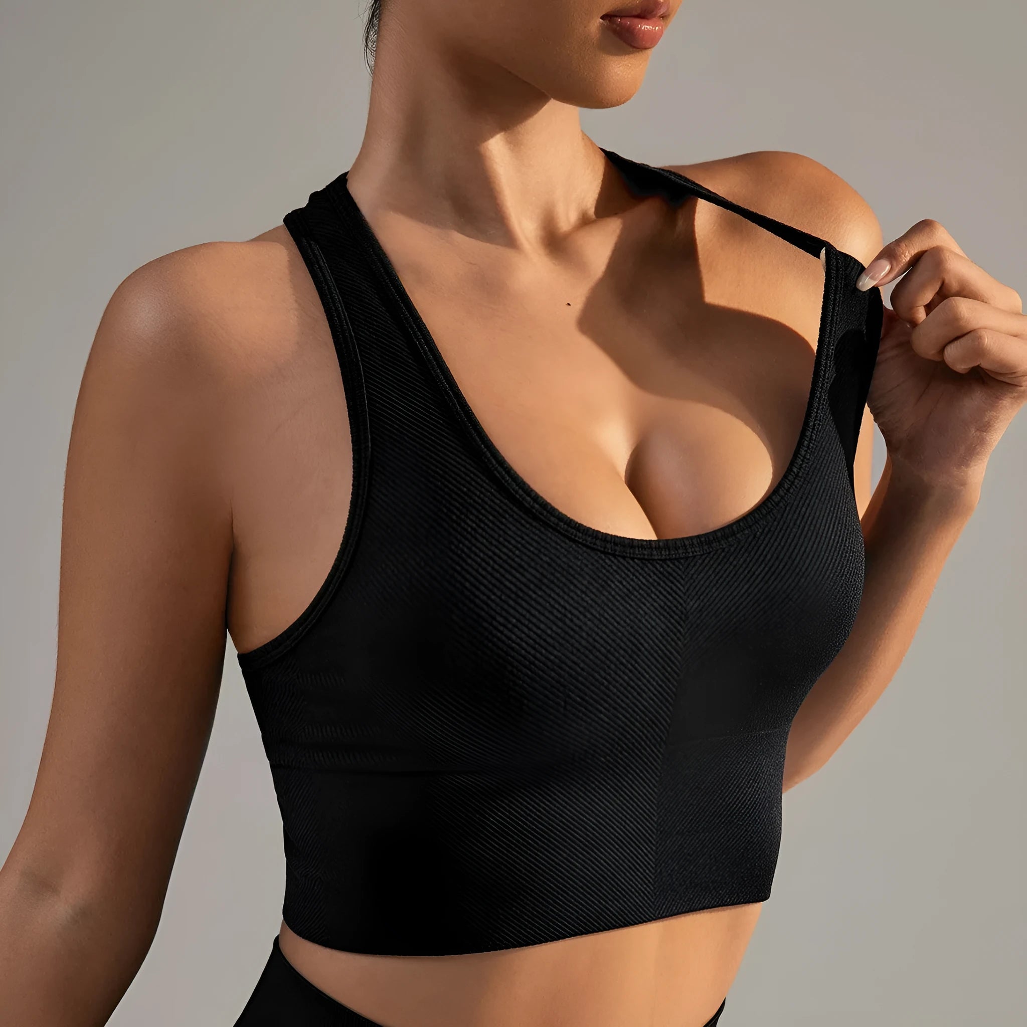 Black cross-back sports bra with moulded cups and fixed double straps on a mannequin