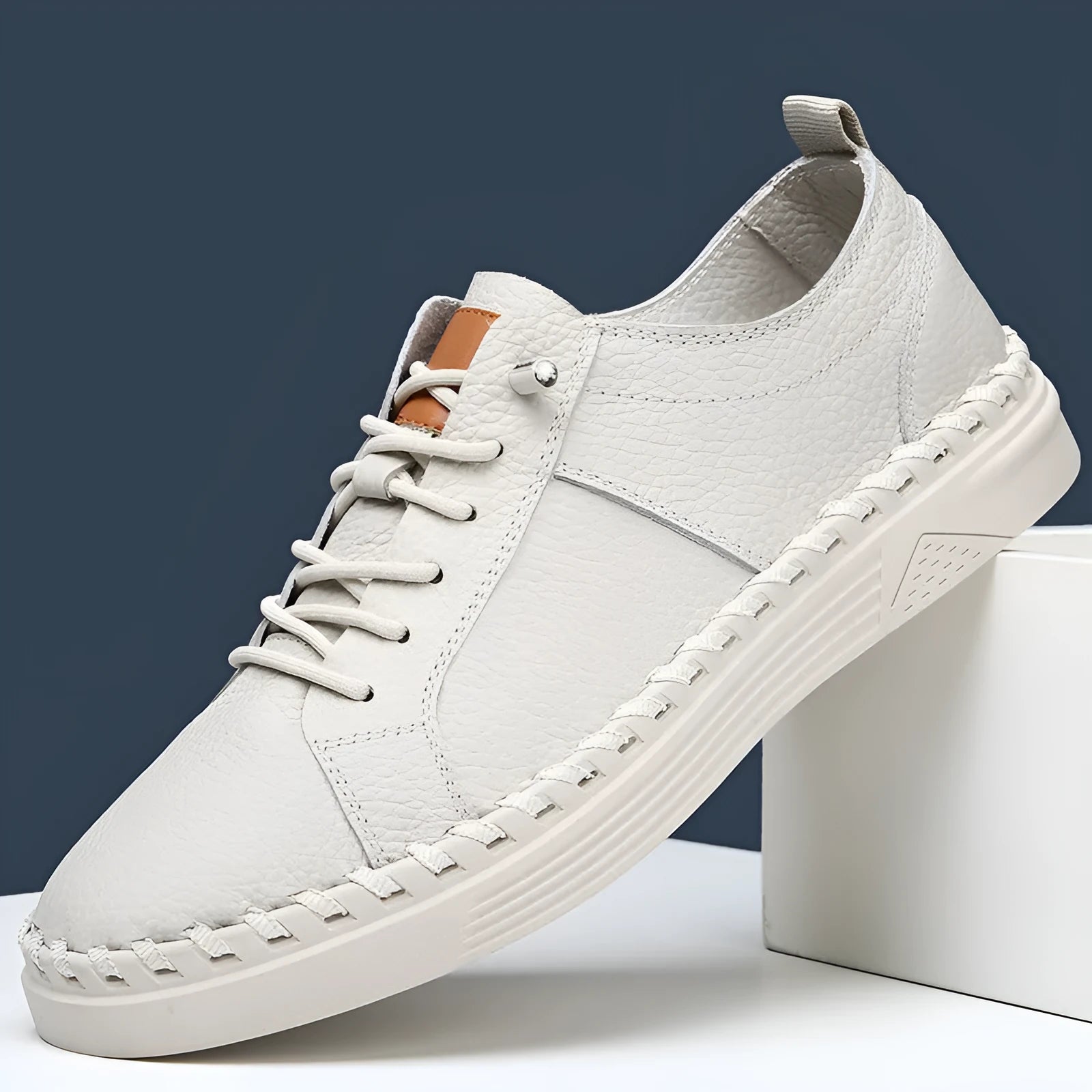 Beige and black men's round-toe cowhide sneakers with mesh lining and stitching detail.