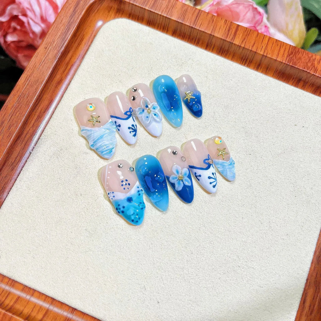 Blue carved designs on transparent fake nails showing summer ice aesthetic