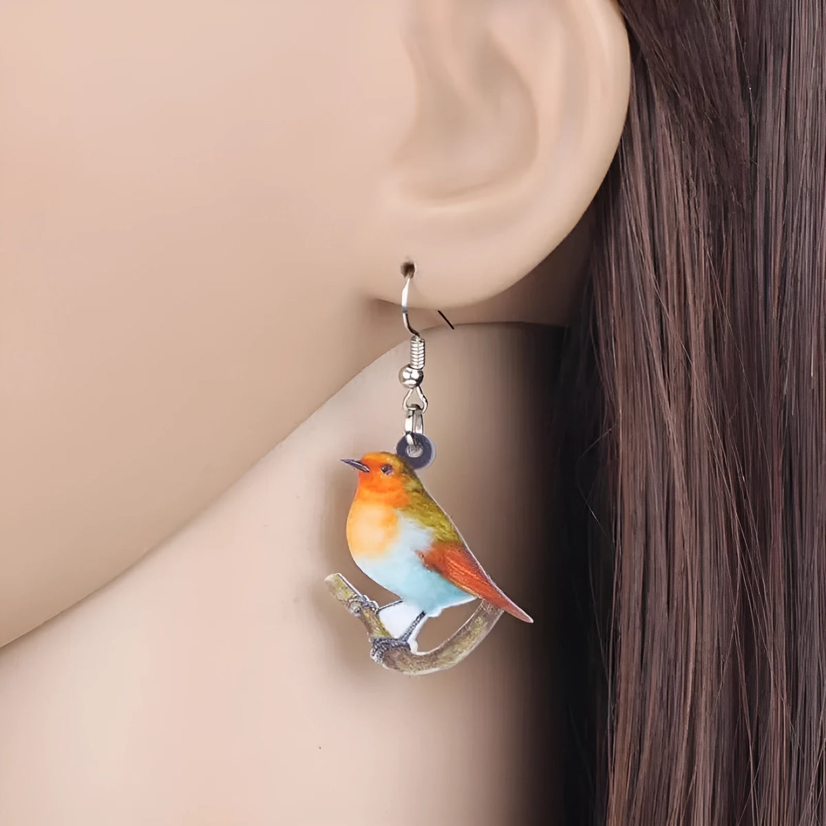 A pair of acrylic pendant earrings with a printed Blue Titmouse and snake design on geometric shapes.