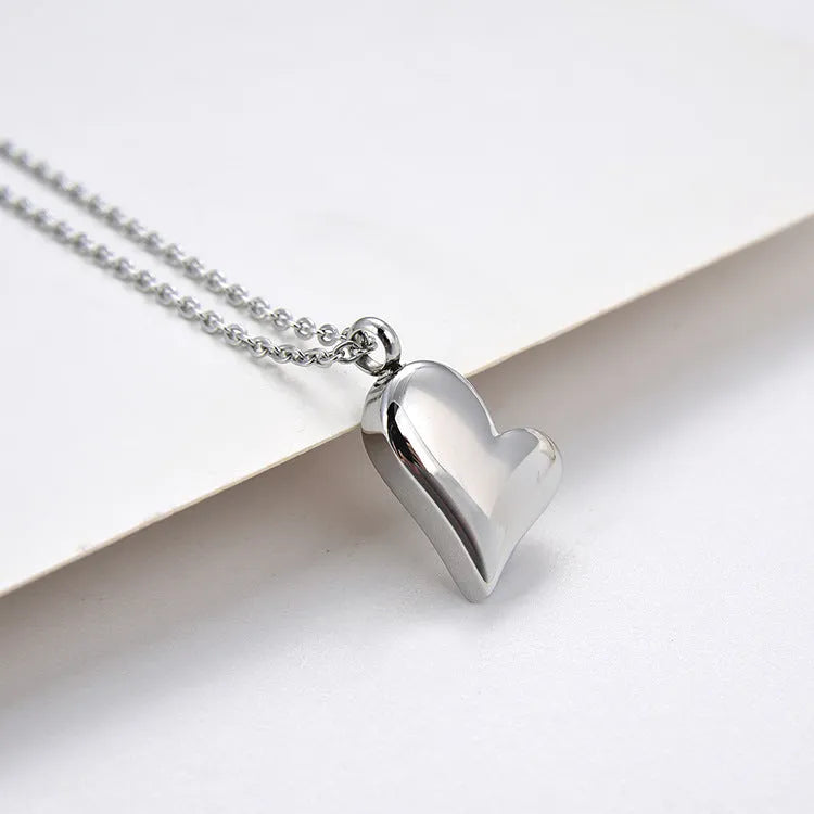 Silver curved peach heart stainless steel pendant necklace on a chain with extension