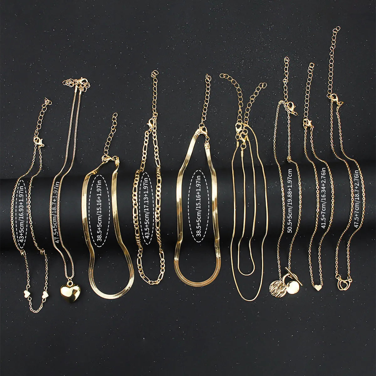 Gold electroplated women's necklace suit with ten pieces showing alloy pendants on snake bone chains