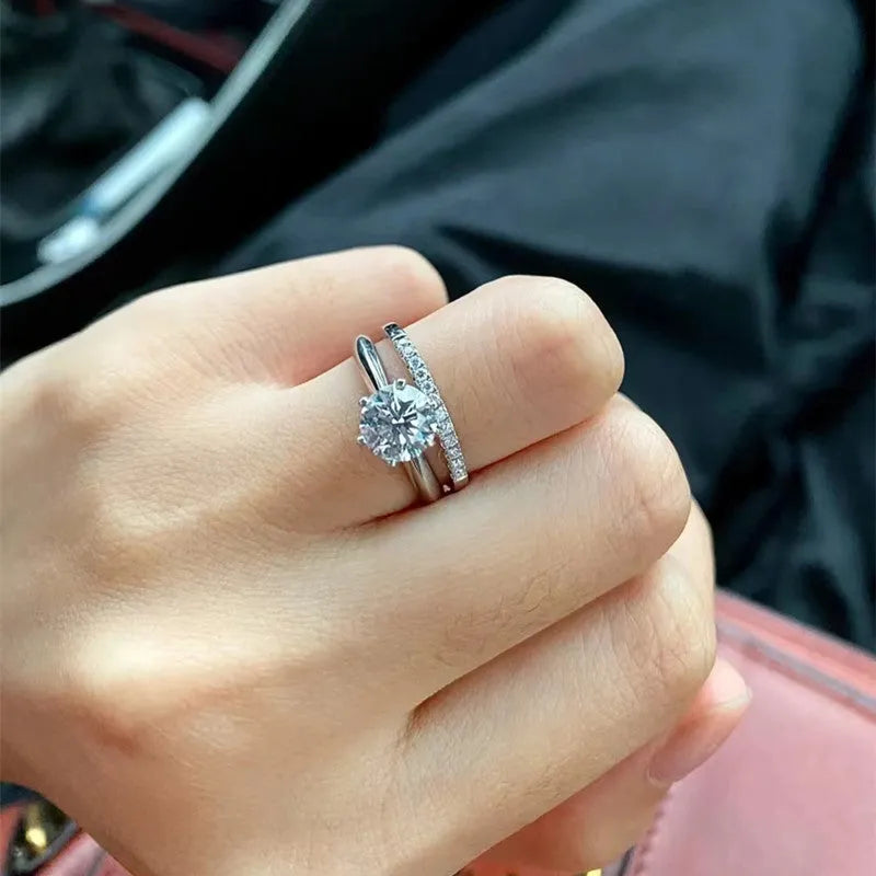 A pair of silver-plated adjustable couple rings with dragon, phoenix, and heart decorations, set with D colour moissanite stones.