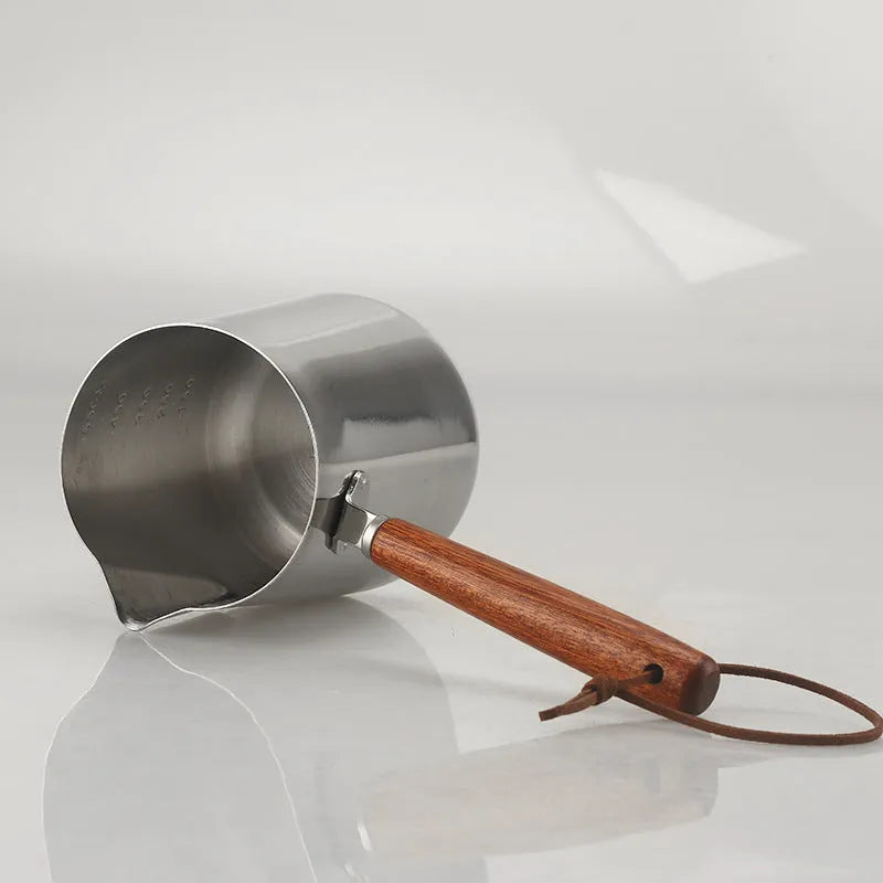 Stainless steel garland coffee cup with wooden handle and interior measurement scale.