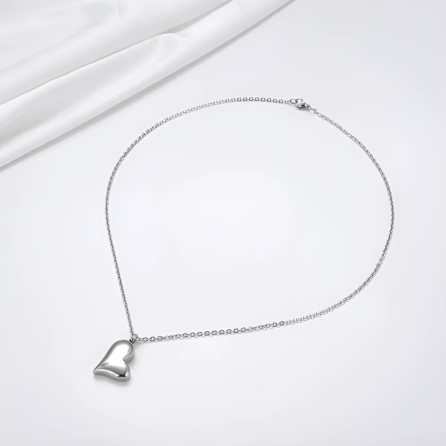 Silver curved peach heart stainless steel pendant necklace on a chain with extension
