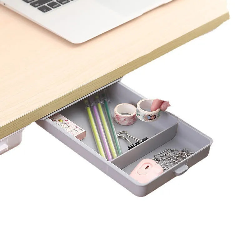 White adhesive under-table storage drawer with grid pattern mounted beneath a wooden desk.