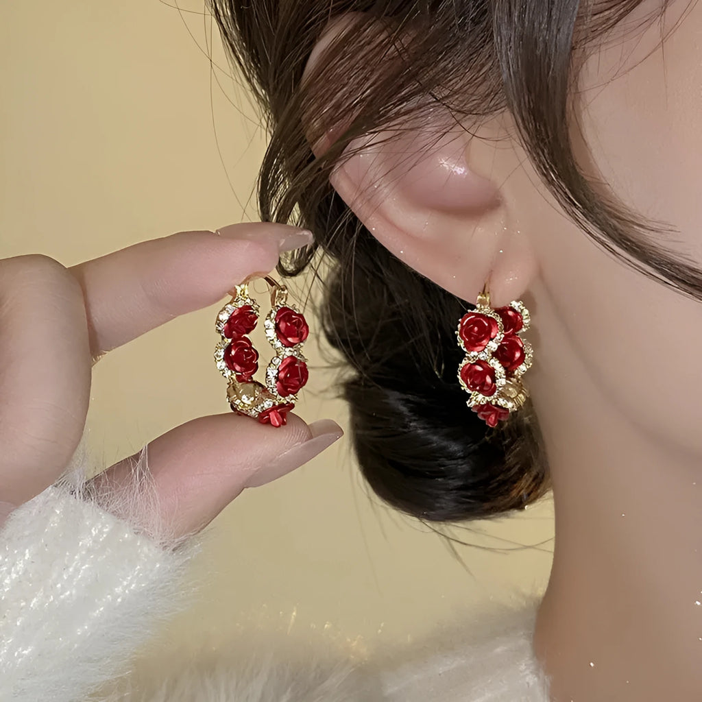 A pair of red flower-shaped alloy clip-on earrings with rose detailing for women.