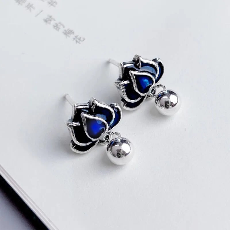 Blue alloy lotus seedpod and tassel dangle ear studs on a white background.