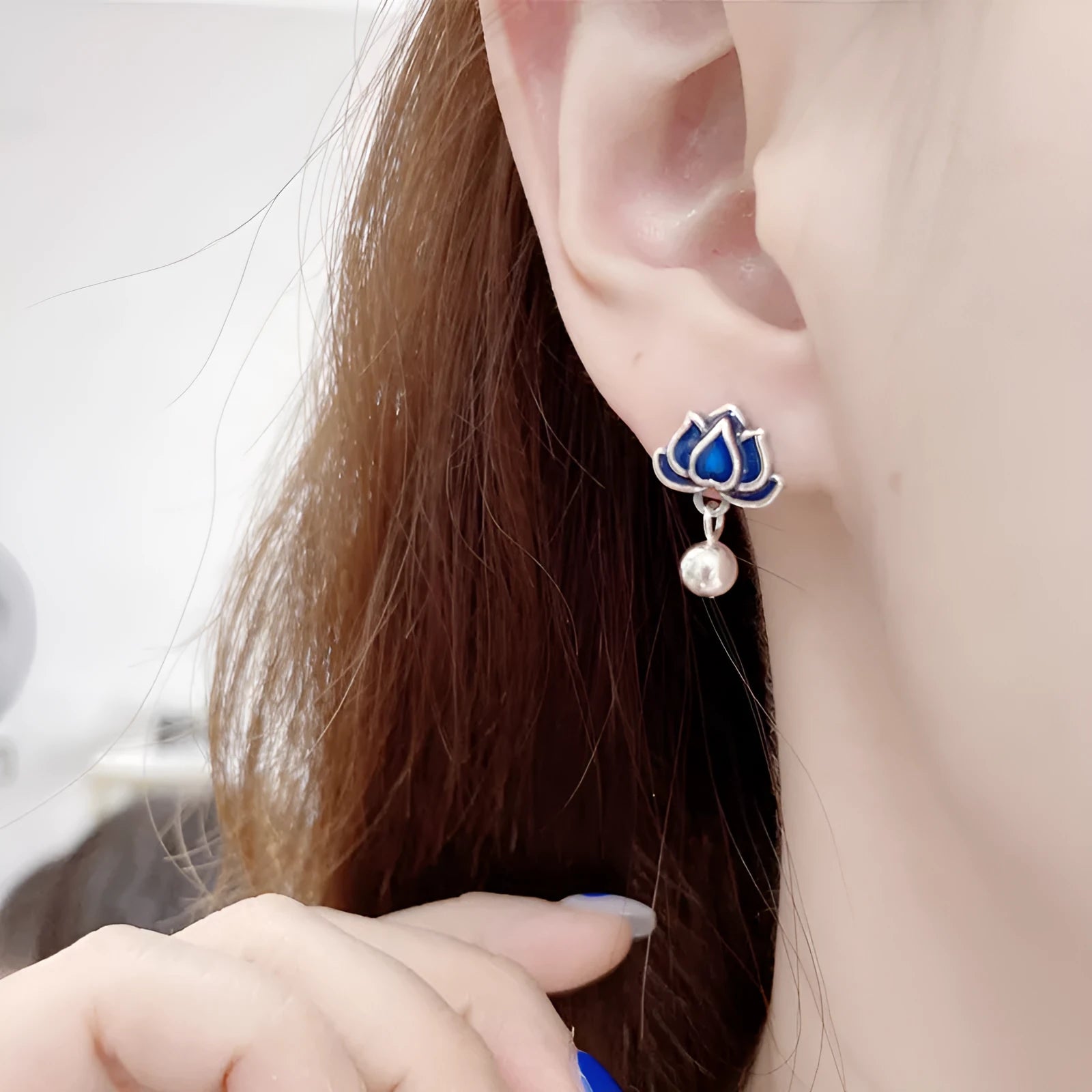 Blue alloy lotus seedpod and tassel dangle ear studs on a white background.