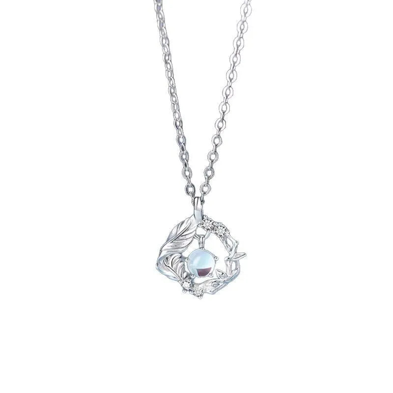 Geometric alloy pendant necklace with eucalyptus and bluebird design on adjustable chain.