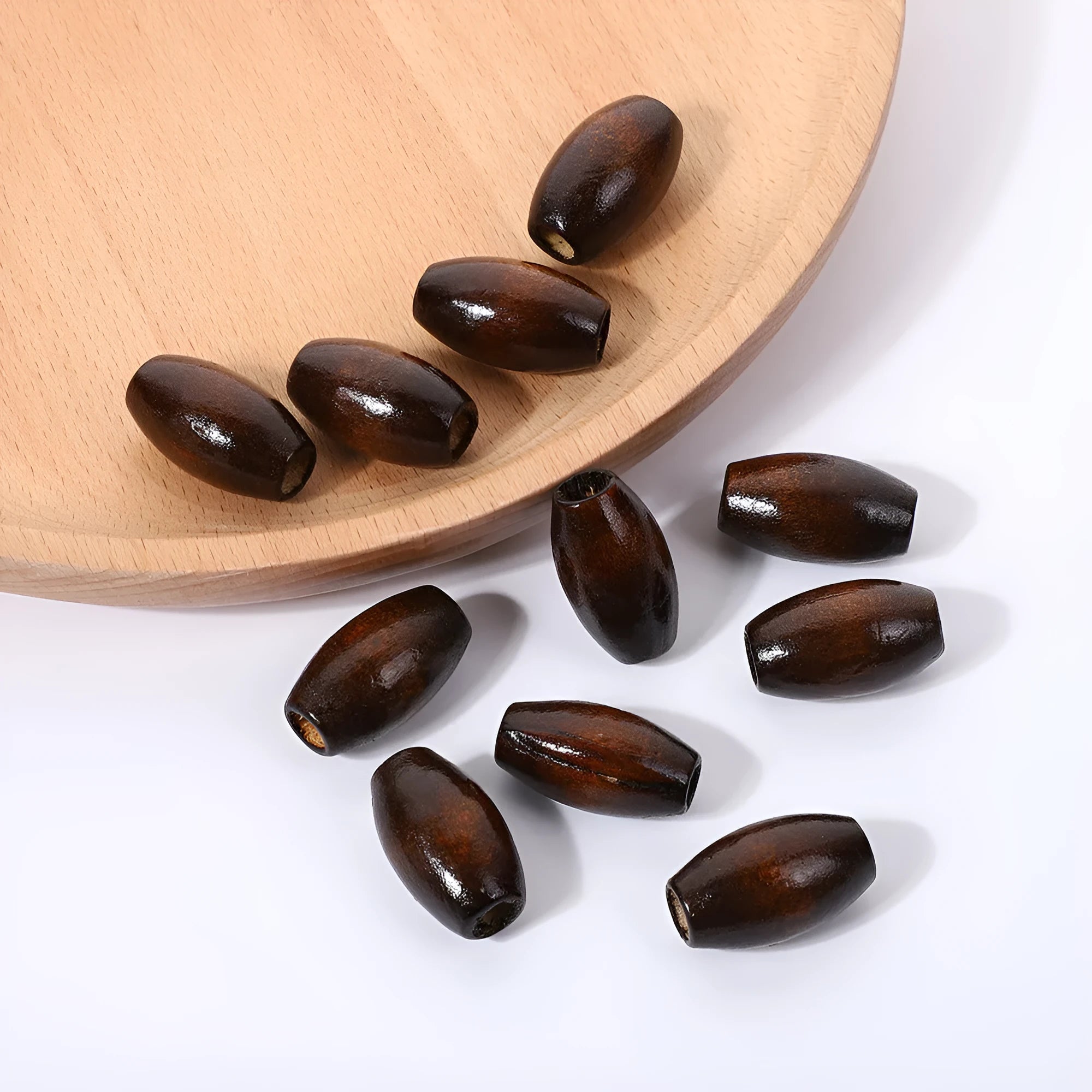 Dark coffee coloured oval wooden beads with M-shaped raised surface design