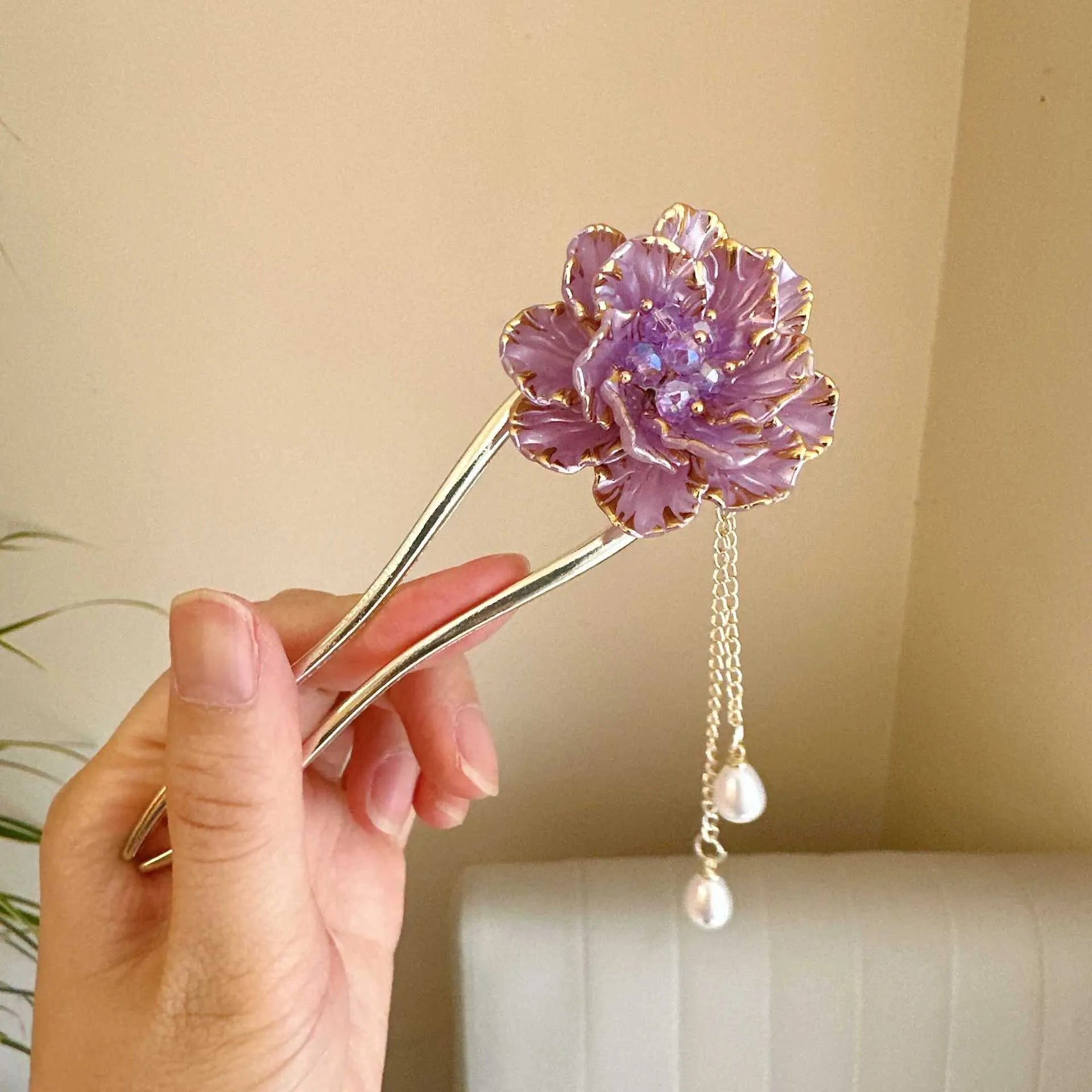 Close-up of a purple peony flower and tassel on a gold-toned U-shaped alloy hairpin.