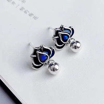 Blue alloy lotus seedpod and tassel dangle ear studs on a white background.