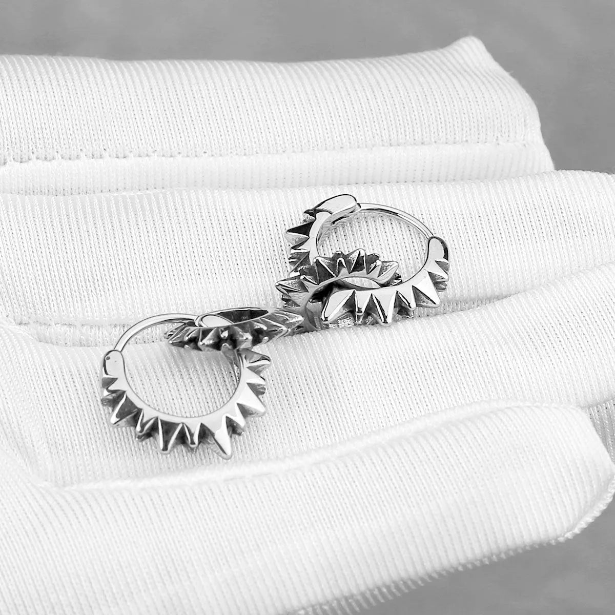 A pair of simple stainless steel round ring earrings with a polished steel colour finish.