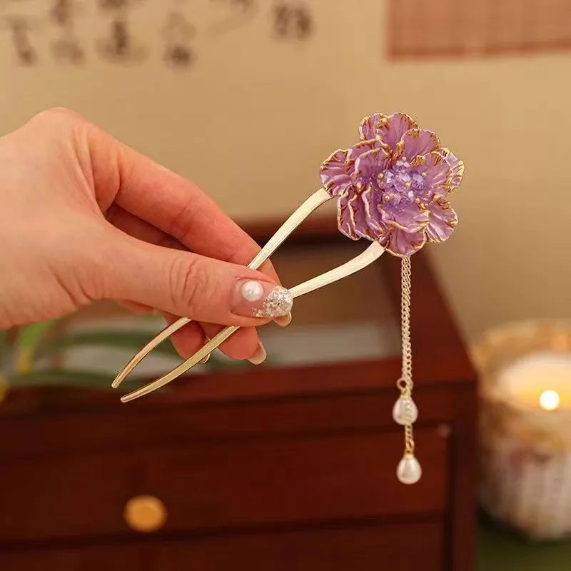 Close-up of a purple peony flower and tassel on a gold-toned U-shaped alloy hairpin.