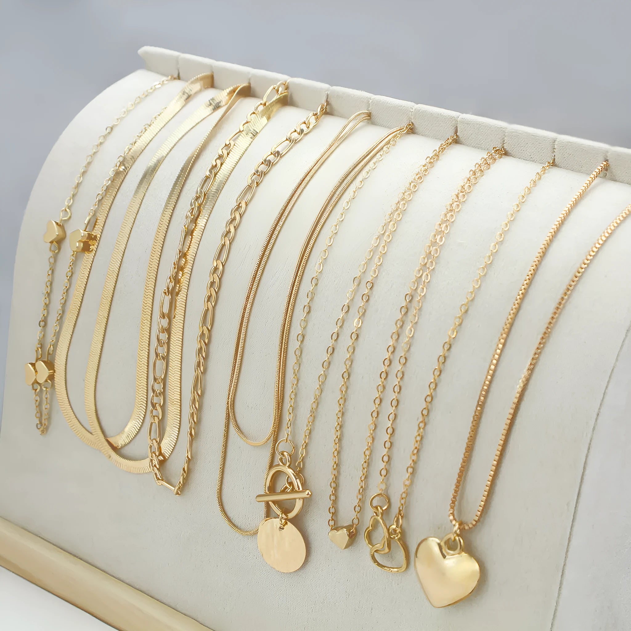 Gold electroplated women's necklace suit with ten pieces showing alloy pendants on snake bone chains