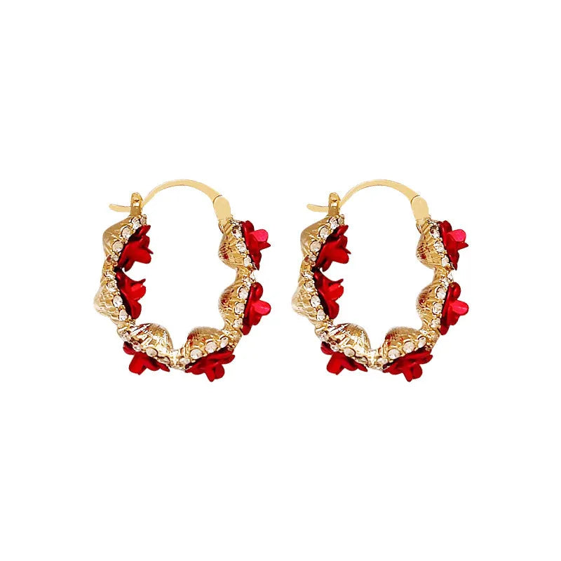 A pair of red flower-shaped alloy clip-on earrings with rose detailing for women.