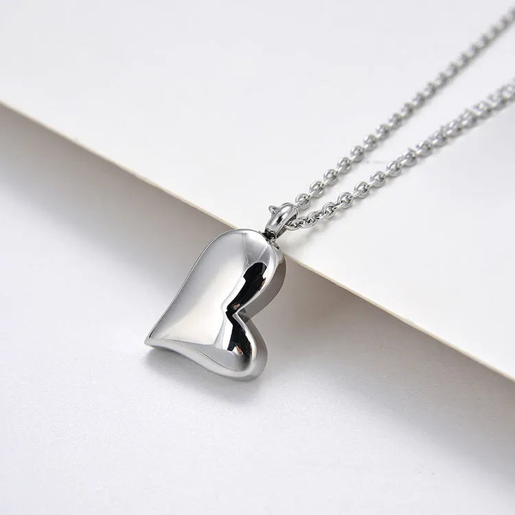 Silver curved peach heart stainless steel pendant necklace on a chain with extension