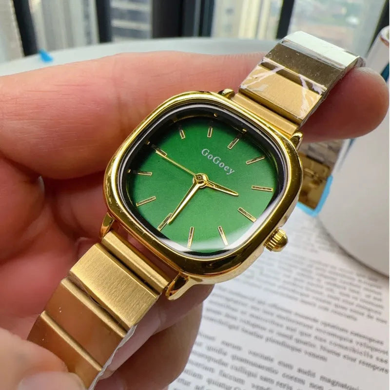 Women's quartz watch with metal case, steel strap and folding buckle, shown in gold or silver with green, white or gold surface