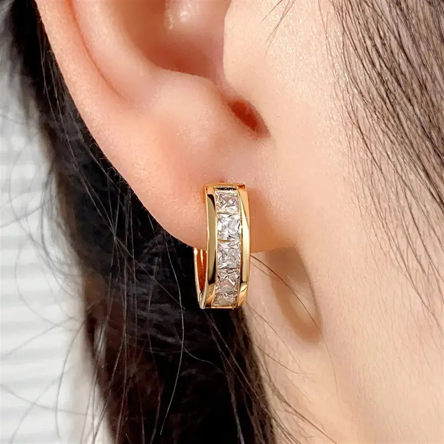 A pair of women's geometric quadrilateral earrings in a gold or silver copper finish.