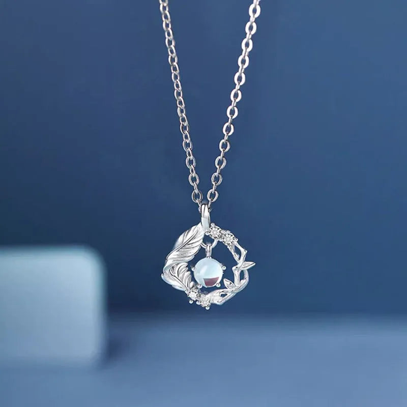 Geometric alloy pendant necklace with eucalyptus and bluebird design on adjustable chain.