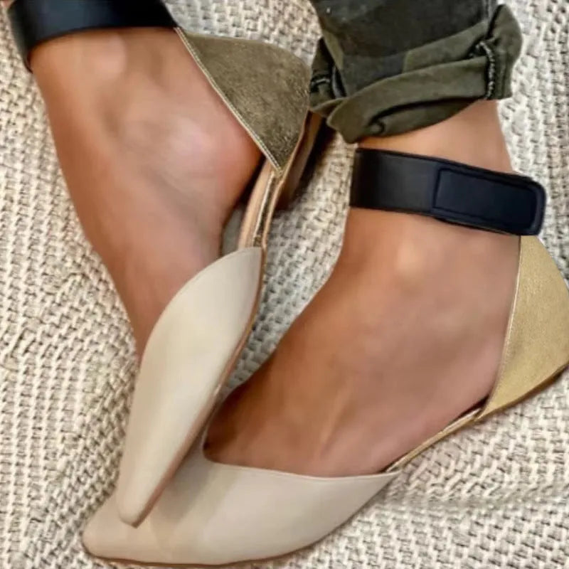 Women's beige velcro strap hollowed sandals with a flat heel on a plain background.
