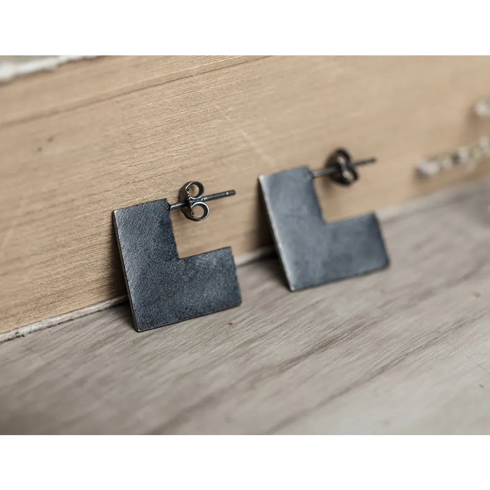 Oxidised black geometric square sterling silver earrings on a white background.