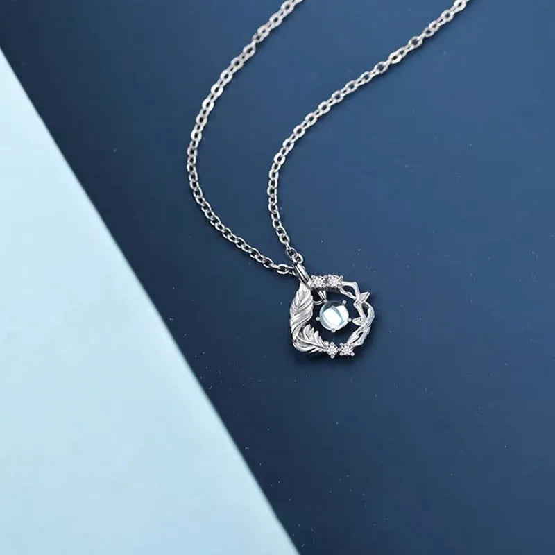 Geometric alloy pendant necklace with eucalyptus and bluebird design on adjustable chain.