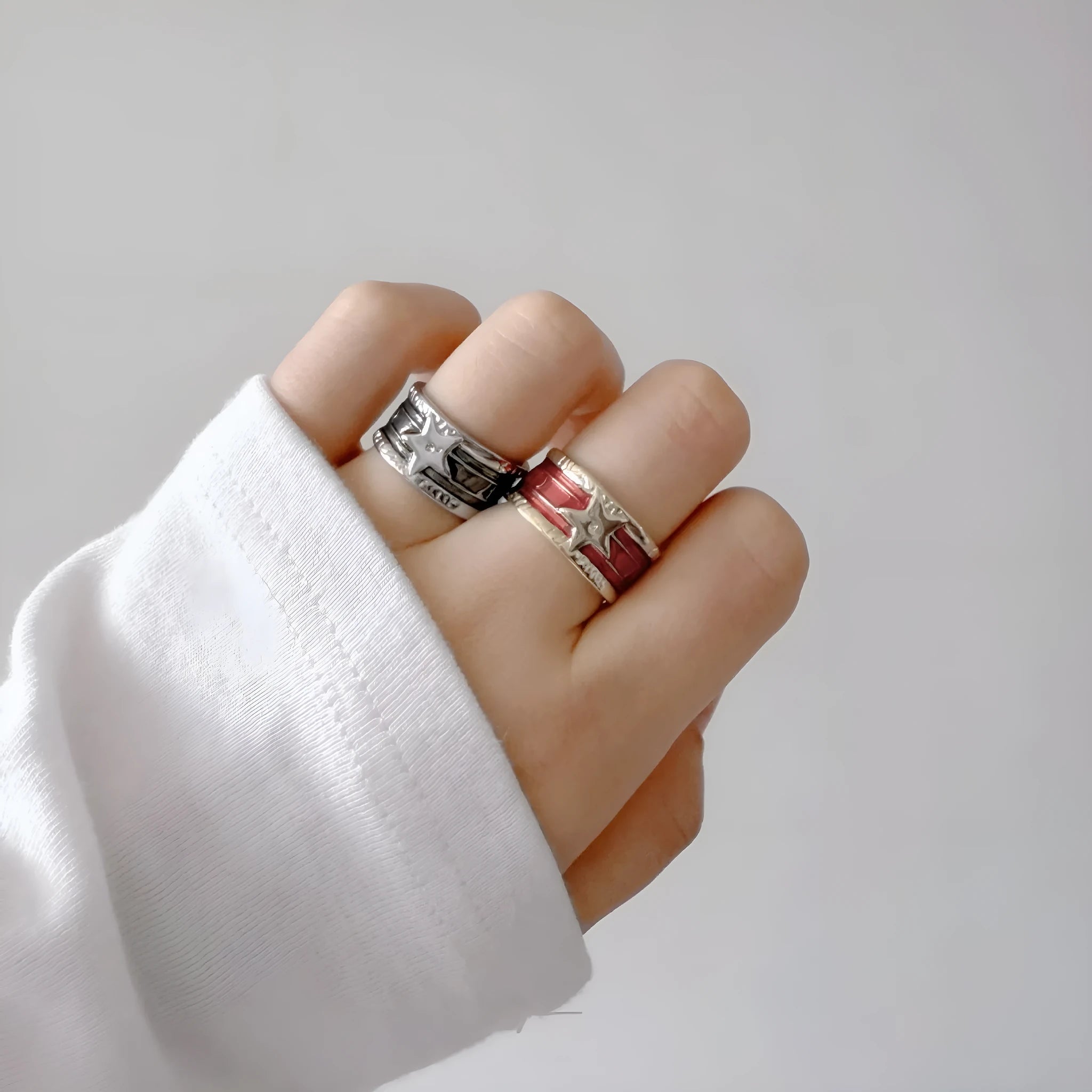Adjustable geometric ring in distressed electroplated copper on a hand, showing colour options.