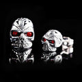 Pair of retro-style skull stud earrings with red gemstone eyes on alloy metal