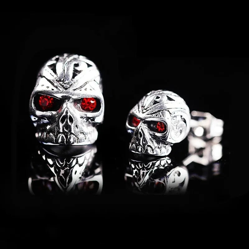 Pair of retro-style skull stud earrings with red gemstone eyes on alloy metal