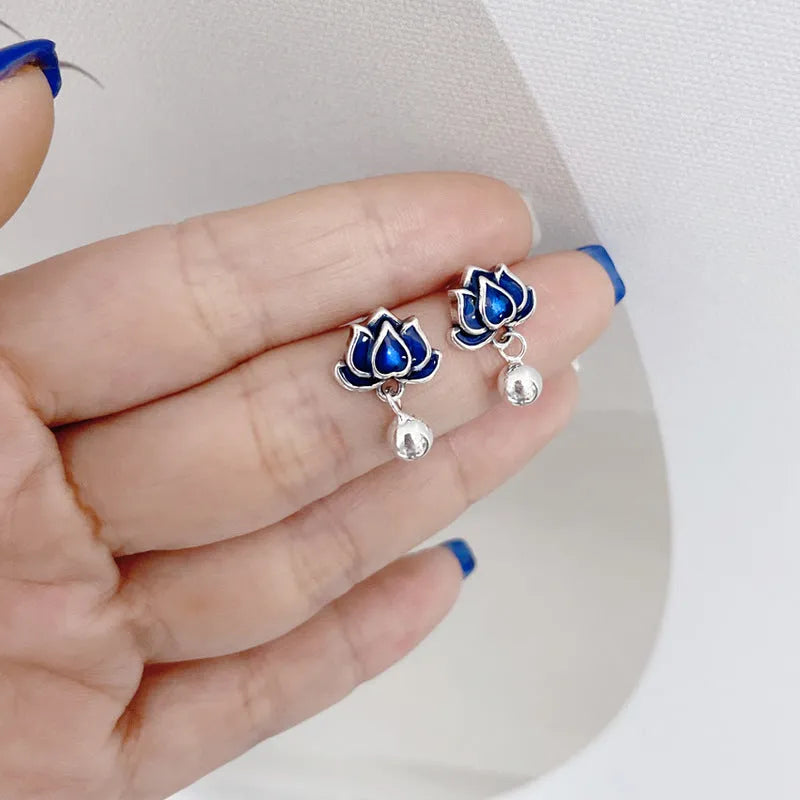Blue alloy lotus seedpod and tassel dangle ear studs on a white background.