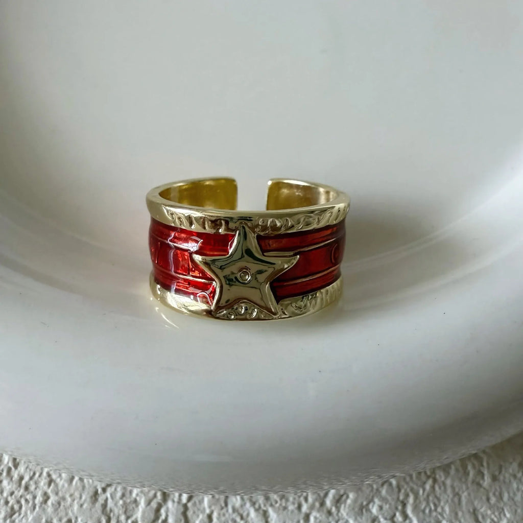 Adjustable geometric ring in distressed electroplated copper on a hand, showing colour options.