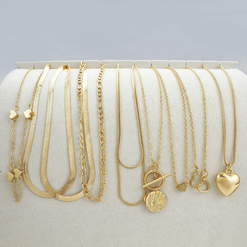 Gold electroplated women's necklace suit with ten pieces showing alloy pendants on snake bone chains