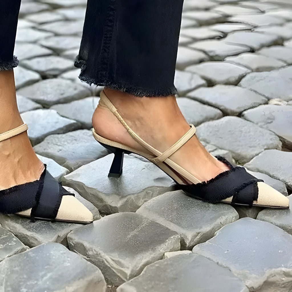 Apricot and black women's pointed toe stiletto heel sandals with a buckle strap.