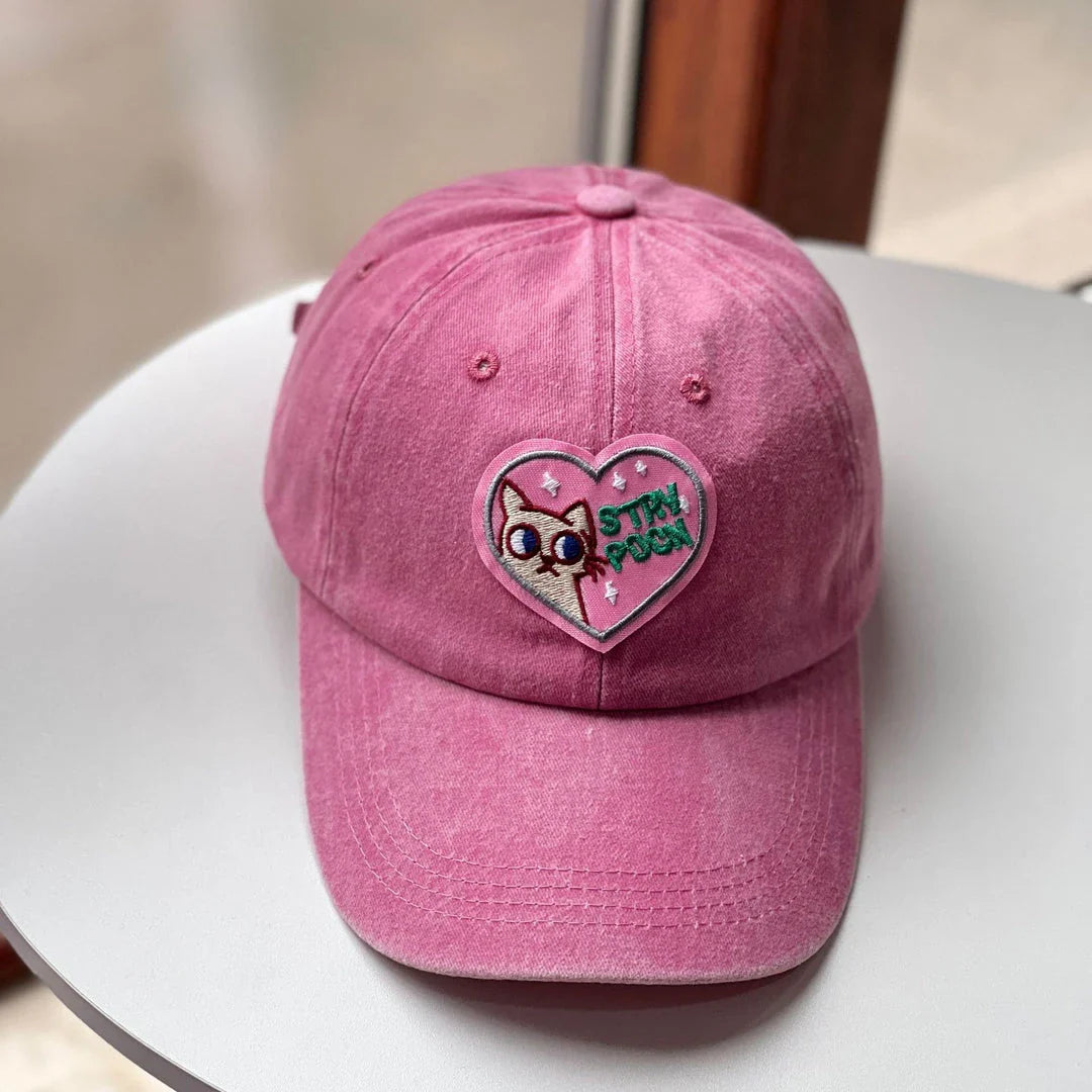 Two pink baseball caps with a cartoon love design, perfect for adding personality to your outfit.