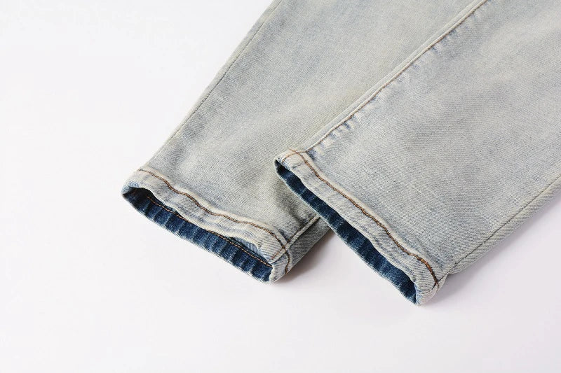 Stylish men's ripped jeans in light blue, featuring a unique distressed look and skinny-fit silhouette inspired by New Zealand's high-street fashion