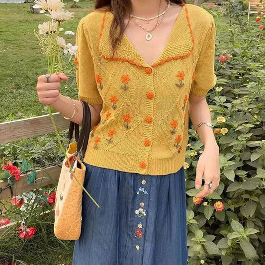 A close-up shot of a short-sleeved women's cardigan in a Western-inspired knit pattern, displaying the vibrant summer yellow color.