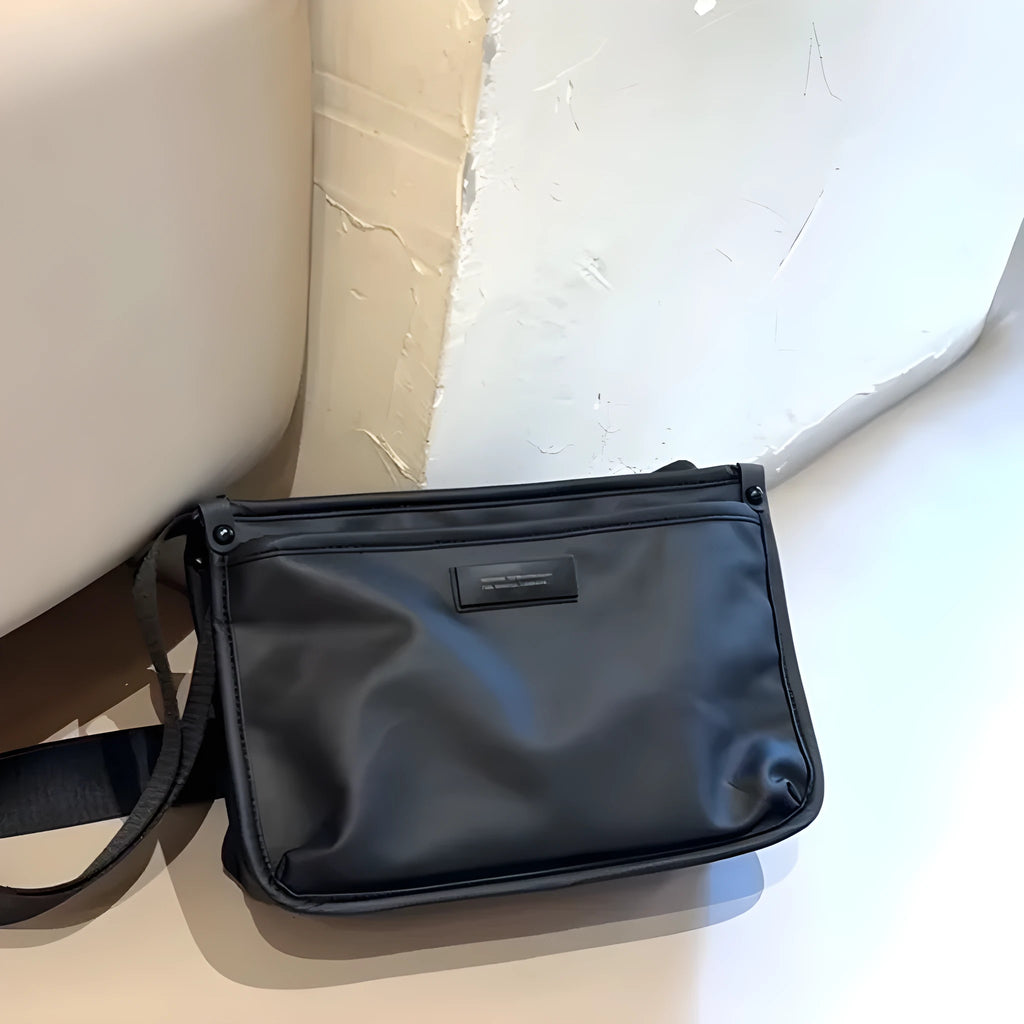 Small square crossbody bag in Oxford cloth, shown in a solid colour on an adjustable strap.
