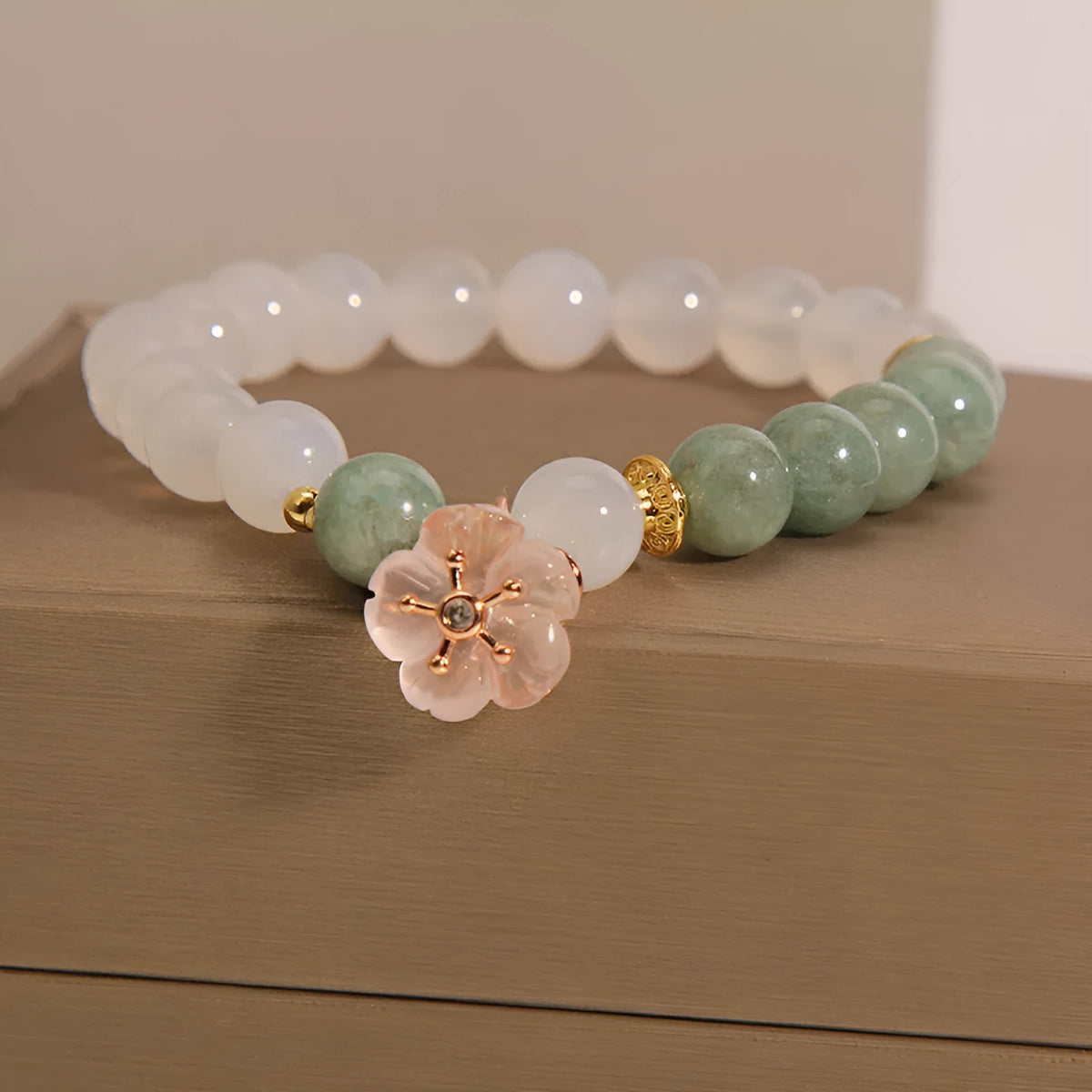 Women's white agate jade bracelet with flower design and pink accents on adjustable sliding knot closure