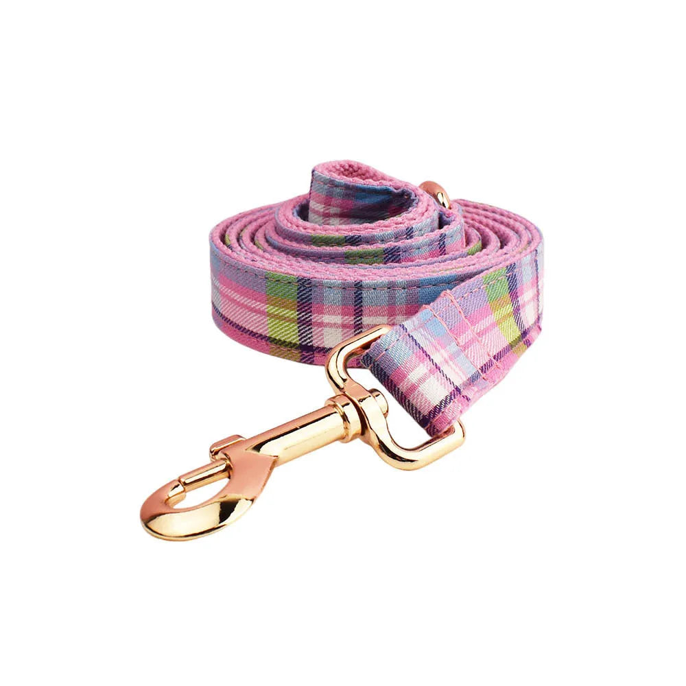 Four-piece cloth dog accessory set showing collar, leash, vest, and bow for coordinated pet styling